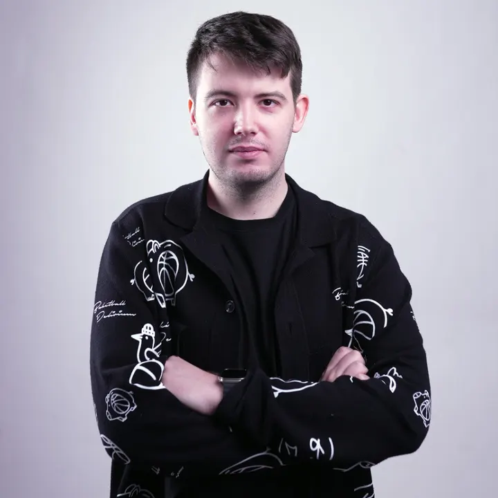Đorđe Pucar, arms crossed, in a black cardigan with white line drawings.
